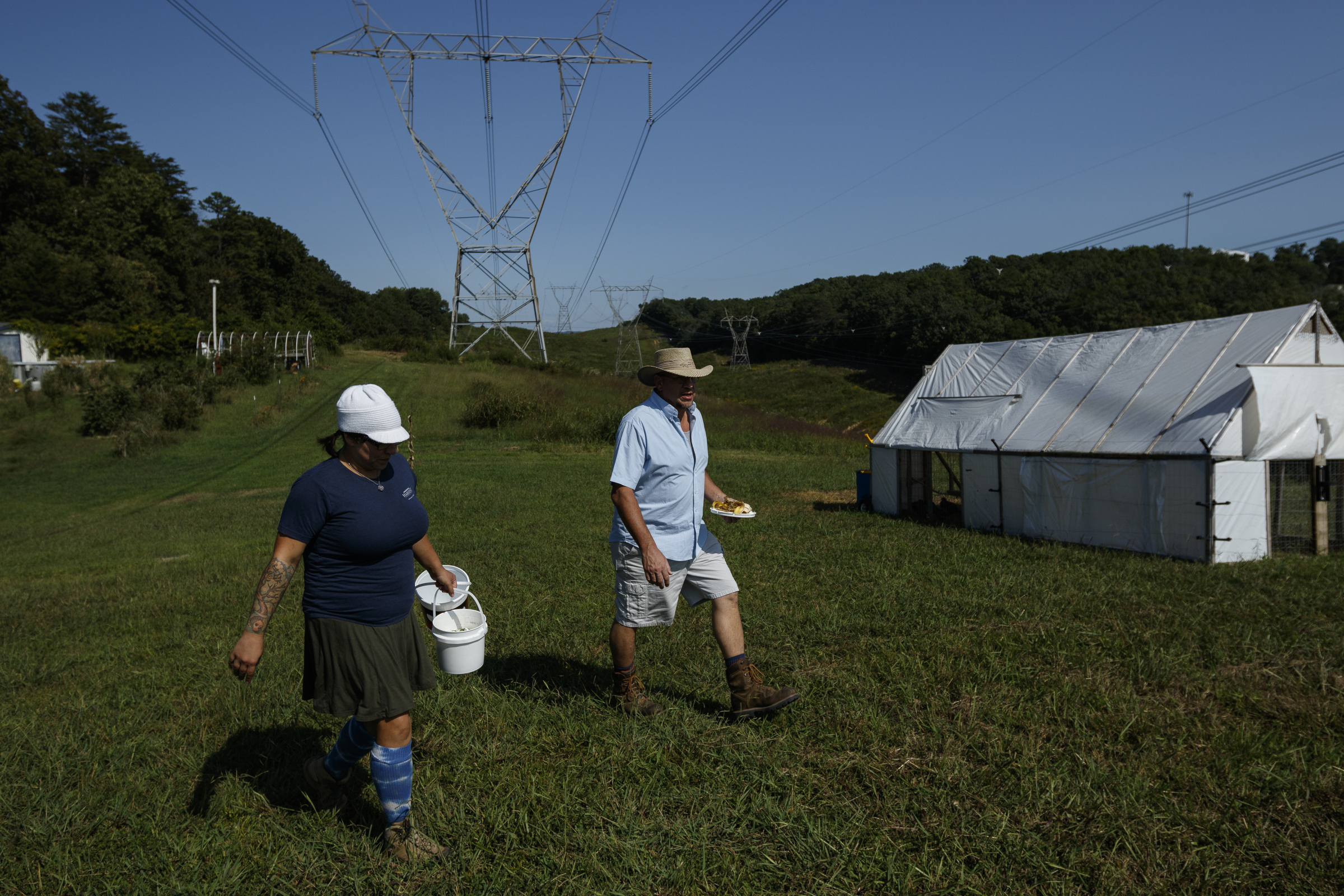 Jessie Gantt-Temple, left, and Robert Temple walk past a mobile chicken coop, called a chicken tractor, to another coop on their farm on Friday, Sept. 8, 2017, in Soddy-Daisy, Tenn. The farm rotates the where their chickens are housed to help maintain sanitary conditions and prevent growth of infectious bacteria like salmonella.