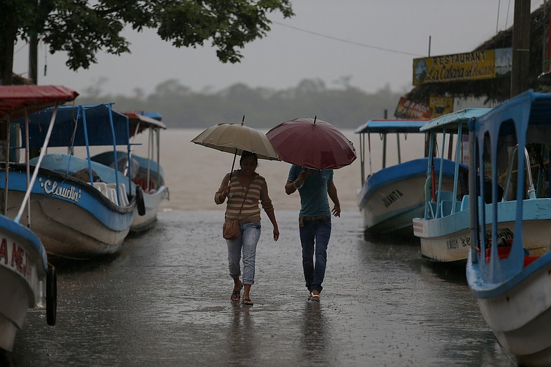 
              Residents walk past boats that were moved on land in preparation for the expected arrival of Hurricane Katia, in Tecolutla, Veracruz state, Mexico, Friday, Sept. 8, 2017. Hurricane Katia in the Gulf of Mexico is stationary north-northeast of Veracruz and forecasters didn't expect much movement overnight. (AP Photo/Eduardo Verdugo)
            