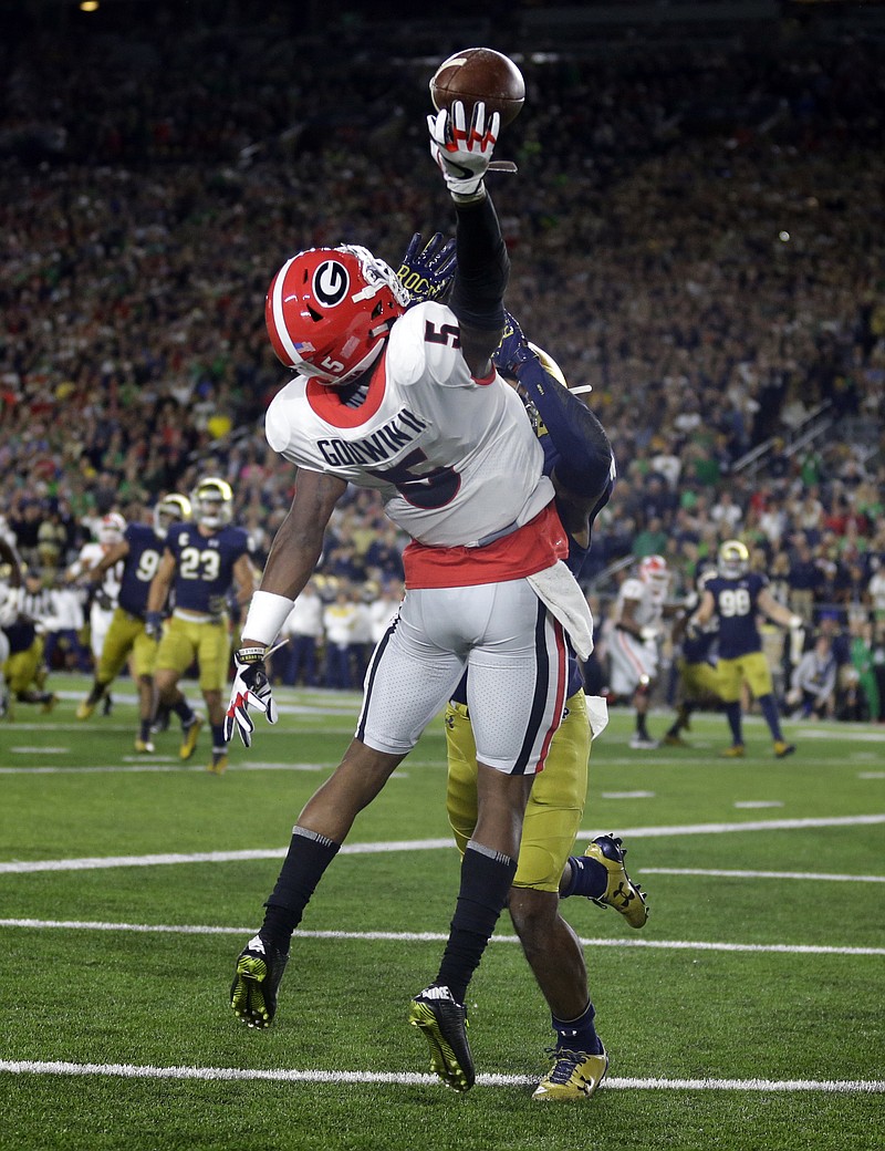 
              Georgia wide receiver Terry Godwin (5) makes a catch over Notre Dame cornerback Julian Love for a touchdown during the first half of an NCAA college football game in South Bend, Ind., Saturday, Sept. 9, 2017. (AP Photo/Michael Conroy)
            