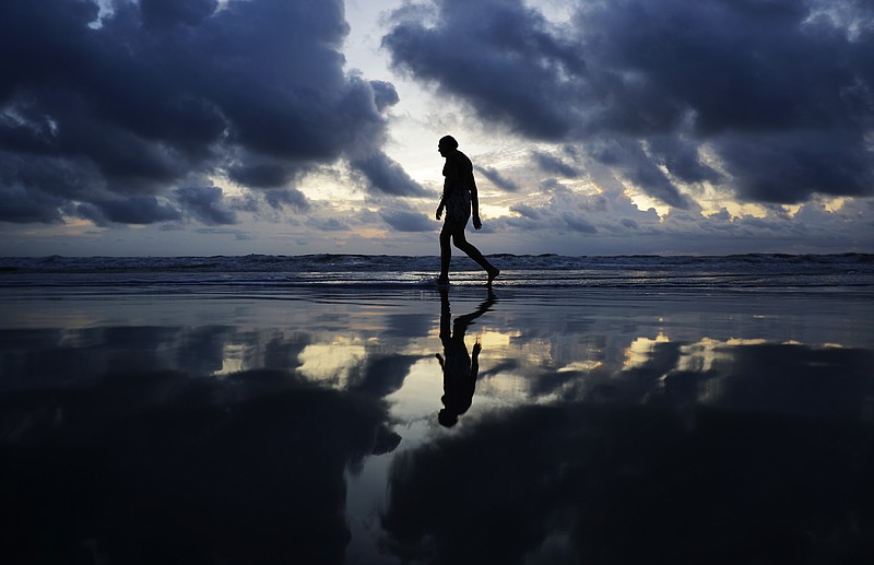 
              A man walks along the beach at sunrise ahead of Hurricane Irma in Daytona Beach, Fla., Friday, Sept. 8, 2017. Coastal residents around South Florida have been ordered to evacuate as the killer storm closes in on the peninsula for what could be a catastrophic blow this weekend. (AP Photo/David Goldman)
            