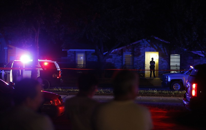 
              Onlookers watch police work the scene of a shooting at a home in Plano, north of Dallas, Texas, Sunday night, Sept. 10, 2017. Authorities in North Texas say several people are dead, including the suspect, after a shooting at the Plano home. (Vernon Bryant/The Dallas Morning News via AP)
            