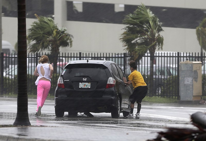 
              Stranded motorists try to get back in their car after a breakdown as Hurricane Irma bears down on the Florida Keys, Sunday, Sept. 10, 2017, in Hialeah, Fla. Wind gusts of 82 mph were reported in Miami. (AP Photo/Alan Diaz)
            