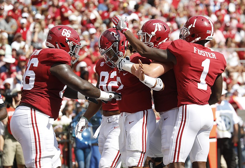 Alabama quarterback Jalen Hurts, center, is surrounded by teammates after a touchdown during Saturday's 41-10 victory over Fresno State.