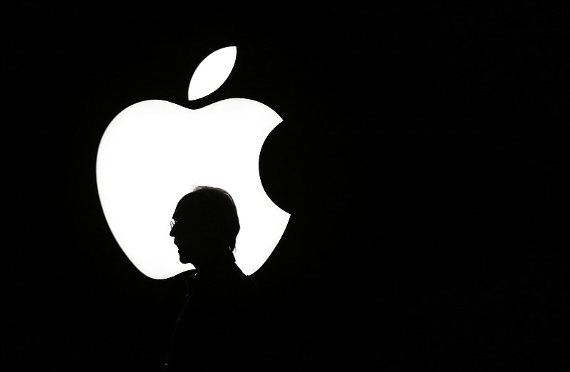 FILE - In this Sept. 9, 2015 file photo, a man walks past the Apple logo during a product display for Apple TV following an Apple event in San Francisco. Television is one of the few screens that has Apple hasn’t conquered, but that may soon change. The world’s richest company appears ready to set out to produce Emmy-worthy programming along the lines of HBO’s “Game of Thrones” and Netflix’s “Stranger Things.”  (AP Photo/Eric Risberg, File)