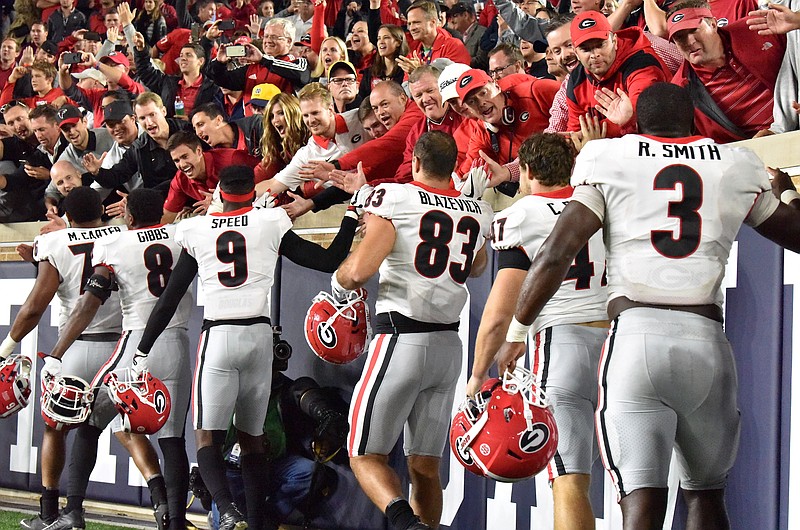 Georgia football players celebrate with their fans after Saturday night's 20-19 win at Notre Dame.