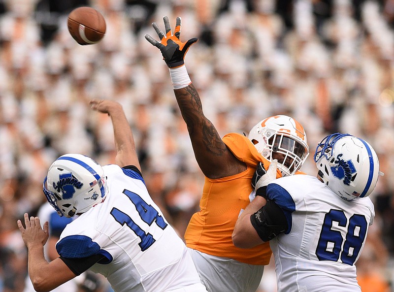 Tennessee's Alexis Johnson, center, pressures Indiana State quarterback Isaac Harker, left, during Saturday's 42-7 victory in Knoxville.