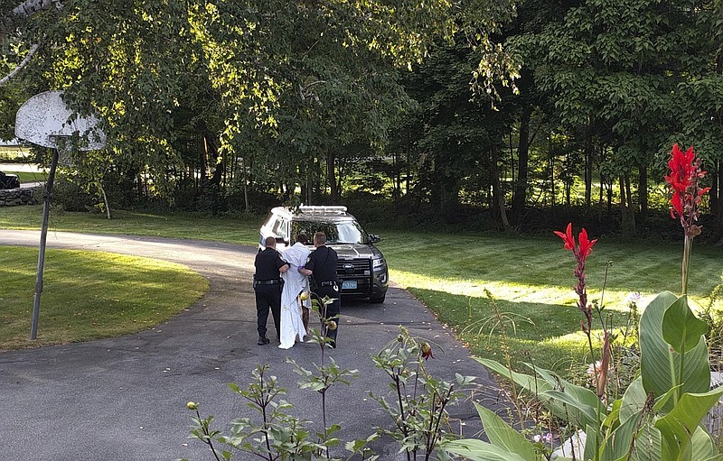 
              In this Friday, Sept. 8, 2017, photo, police officers take Orion Krause, covered in a white sheet, to a police vehicle in Groton, Mass. The 22-year-old recent Oberlin College graduate and jazz drummer from Maine will face murder charges Monday in the slayings of four adults found at a Massachusetts home. (Courtesy via AP)
            