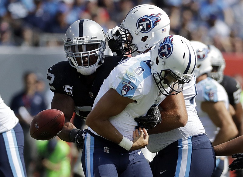 Tennessee Titans quarterback Marcus Mariota (8) fumbles the ball as he is hit by Oakland Raiders defensive end Khalil Mack (52) in the second half of an NFL football game Sunday, Sept. 10, 2017, in Nashville, Tenn. The Titans recovered the ball. (AP Photo/James Kenney)