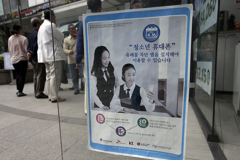 
              In this May 15, 2015 file photo, a promotional banner of mobile apps that block harmful contents, is posted on the door at a mobile store in Seoul, South Korea. The banner reads: "Young smartphone users, you must install apps that block harmful content." A South Korean child-monitoring smartphone app that was removed from the market in 2015 after it was found to be riddled with security holes has been reissued under a new name and puts children at risk, researchers said Monday, Sept. 11, 2017. (AP Photo/Lee Jin-man, File)
            