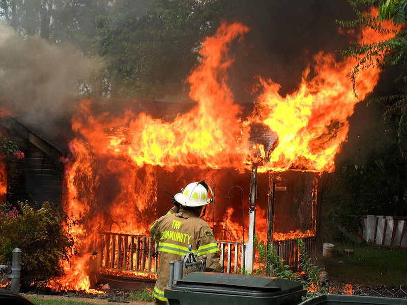 A Tri-Community volunteer firefighter battles a blaze as it consumes a small house located near the jurisdictional line with the Chattanooga Fire Department and Tri-Community Volunteer Fire Department. Not knowing for sure whose jurisdiction it was, both departments responded. Tri-Com firefighters were the first to arrive on the scene.