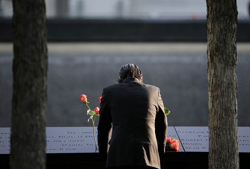 A man stands at the edge of a waterfall pool at ground zero during a ceremony on the 16th anniversary of the 9/11 attacks in New York, Monday, Sept. 11, 2017. Holding photos and reading names of loved ones lost 16 years ago, 9/11 victims' relatives marked the anniversary of the attacks with a solemn and personal ceremony. (AP Photo/Seth Wenig)