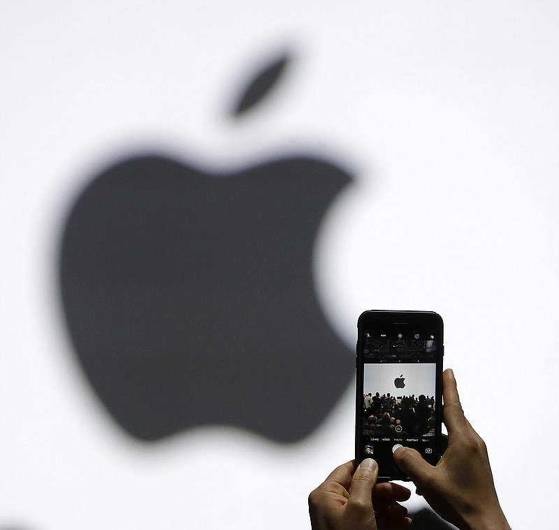 FILE - In this Monday, June 5, 2017, file photo, a person takes a photo of an Apple logo before an announcement of new products at the Apple Worldwide Developers Conference in San Jose, Calif. Apple is expected to demand $1,000 for the fanciest iPhone that it has ever made, thrusting the market into a new financial frontier that will test how much consumers are willing to pay for a device that has become an indispensable part of modern life. (AP Photo/Marcio Jose Sanchez, File)