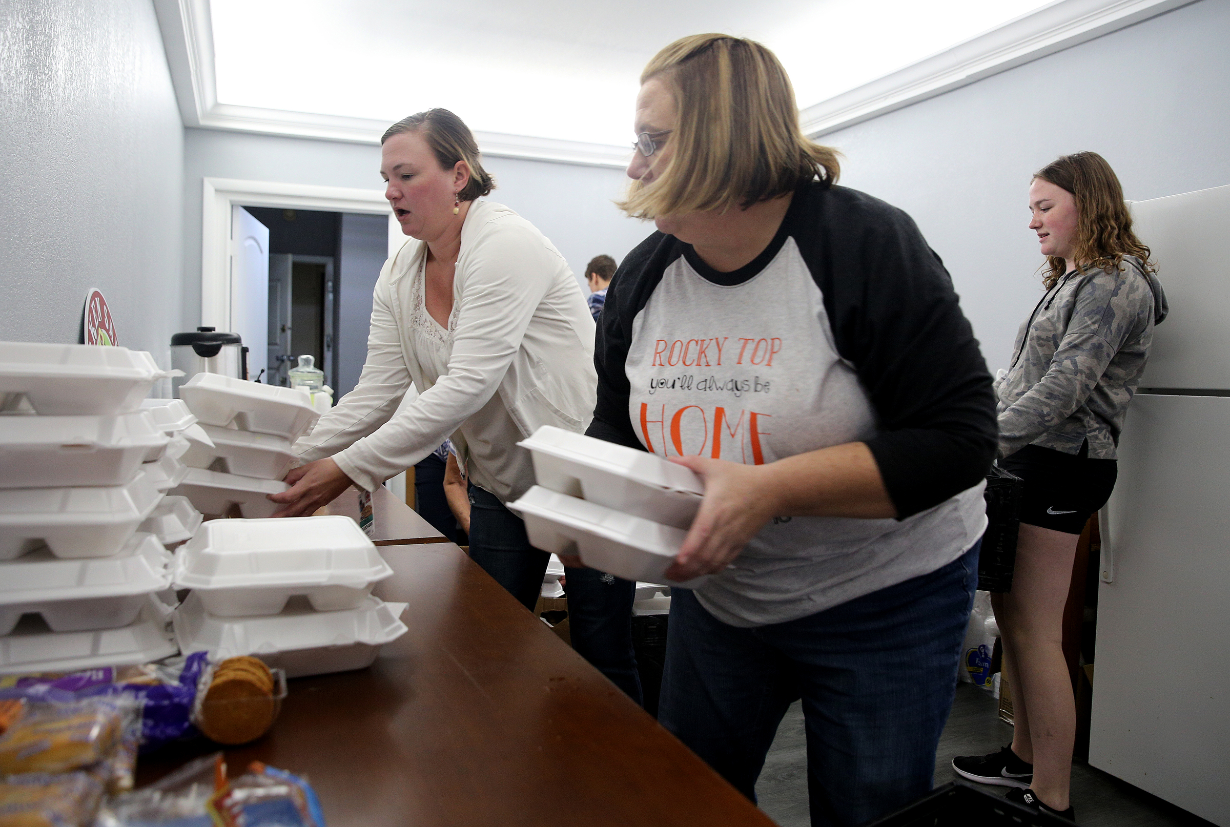 Jessica Steinman, Glenda Bonner and Annika Steinman arrange plates of barbecue for guests Monday, Sept. 11, 2017, at the Budgetel Inn in East Ridge, Tenn. About 300 guests were staying at the hotel after fleeing Hurricane Irma.