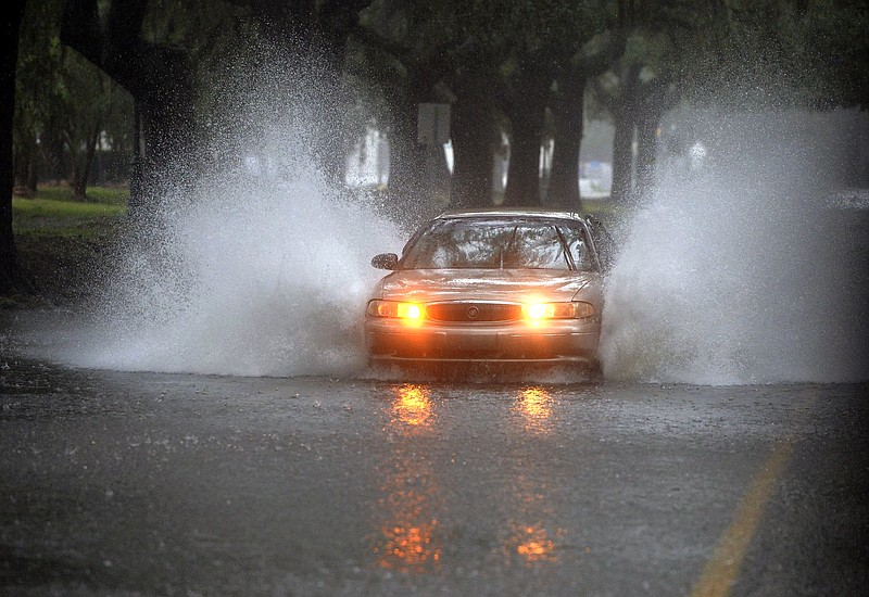 Rain from Tropical Storm Irma makes Victory Drive next to Daffin Park a water challenge to drivers Monday, Sept. 11, 2017, in Savannah, Ga. (Steve Bisson/Savannah Morning News via AP)