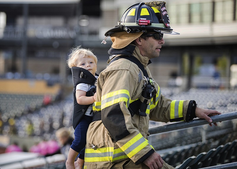 In a Saturday, Sept. 9, 2017 photo, Kearney firefighter George Wiedel climbs stairs with his son Greyson strapped to his back during a 9/11 Memorial Stair Climb at Werner Park in Papillion, Neb. Participants climbed 110 flights of stairs in remembrance of the 110 flights firefighters climbed at the World Trade Center. (Rebecca S. Gratz/Omaha World-Herald via AP)


