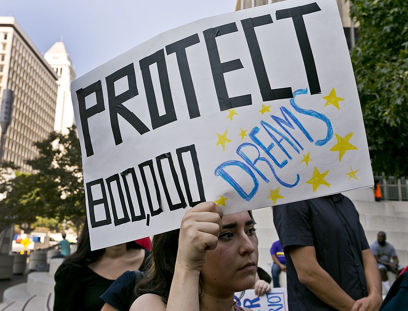 
              FILE - In this Sept. 1, 2017 file photo, a woman joins a rally in support of the Deferred Action for Childhood Arrivals, or DACA program, outside the Edward Roybal Federal Building in downtown Los Angeles Friday, Sept. 1, 2017. California Attorney General Xavier Becerra filed a lawsuit Monday, Sept. 11, against the Trump administration over its decision to end a program that protects young immigrants from deportation who were brought to the U.S. illegally as children or by parents who overstayed visas. (AP Photo/Damian Dovarganes, File)
            