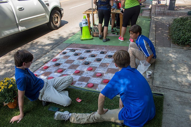 A chalkboard checkers game in a parking spot was one of the activities at the 2016 Park(ing) Day.