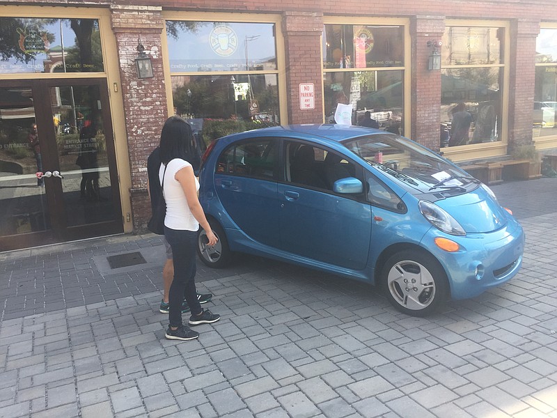 Visitors to the Chattanooga Electric Vehicle Tail Gate Party over the weekend inspect an all-electric Mitsubishi MiEV.