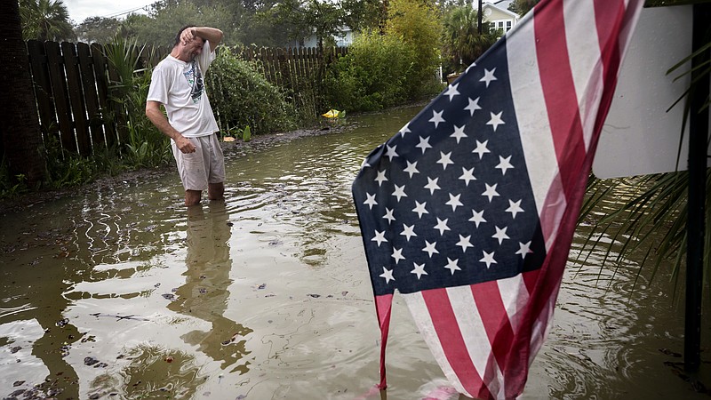 
              Tybee Island resident Joe Murphy wipes the sweat off his face while standing in knee deep water from Tropical Storm Irma outside his house, Monday, Sept., 11, 2017, on Tybee Island, Ga. (AP Photo/Stephen B. Morton)
            