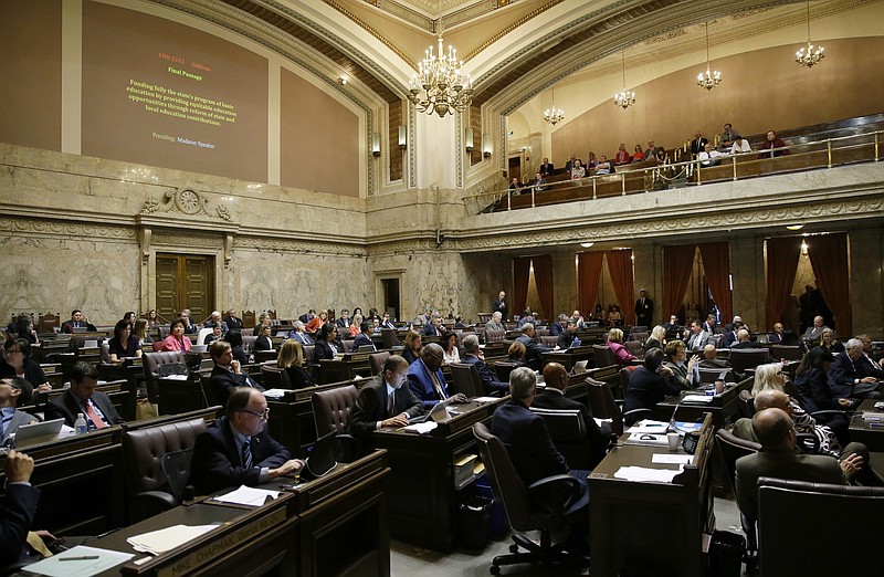 
              FILE - In this June 30, 2017, file photo, representatives work on the House floor during discussion of a bill to fully fund education in Washington state at the Capitol in Olympia, Wash. A coalition of news organizations led by The Associated Press is suing the Washington Legislature over its assertion that state lawmakers aren't required to turn over daily schedules, text messages, emails and other materials related to their work. (AP Photo/Ted S. Warren, File)
            