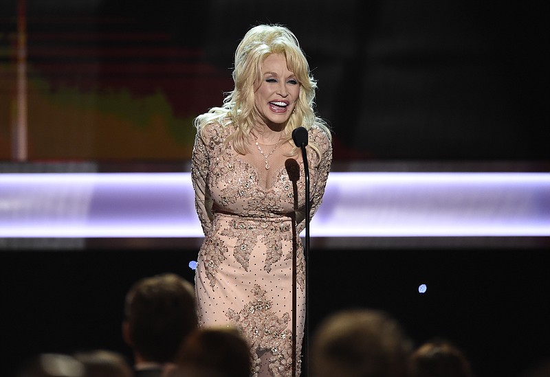 
              FILE - In this Jan. 29, 2017, file photo, Dolly Parton presents the Lifetime Achievement Award at the 23rd annual Screen Actors Guild Awards at the Shrine Auditorium & Expo Hall in Los Angeles. Five people have been charged in Tennessee with conspiring to defraud the My People Fund of Dolly Parton's Dollywood Foundation, set up to help people affected by wildfires last year. (Photo by Chris Pizzello/Invision/AP, File)
            