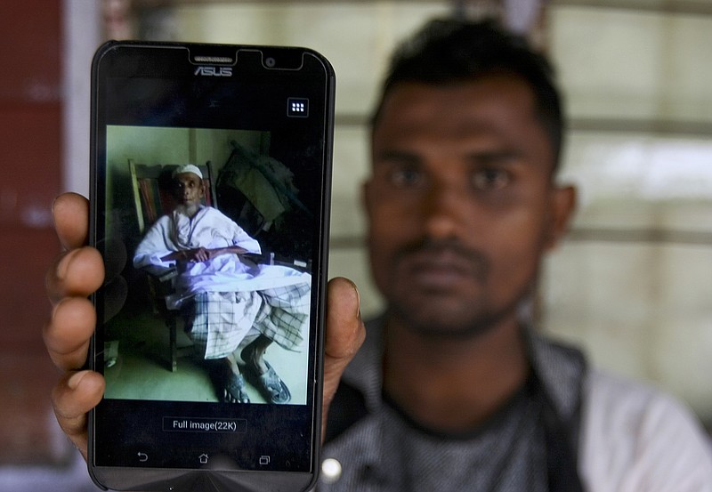 
              In this Tuesday, Sept. 12, 2017, photo, Rohingya refugee Muhammad Ayub shows off a picture of his grandfather allegedly killed during recent violence in Myanmar, in Klang on the outskirts of Kuala Lumpur, Malaysia. Recent violence in Myanmar has driven hundreds of thousands of Rohingya Muslims to seek refuge across the border in Bangladesh. There are some 56,000 Rohingya refugees registered with the U.N. refugee agency in Malaysia, with an estimated 40,000 more whose status has yet to be assessed. (AP Photo/Daniel Chan)
            