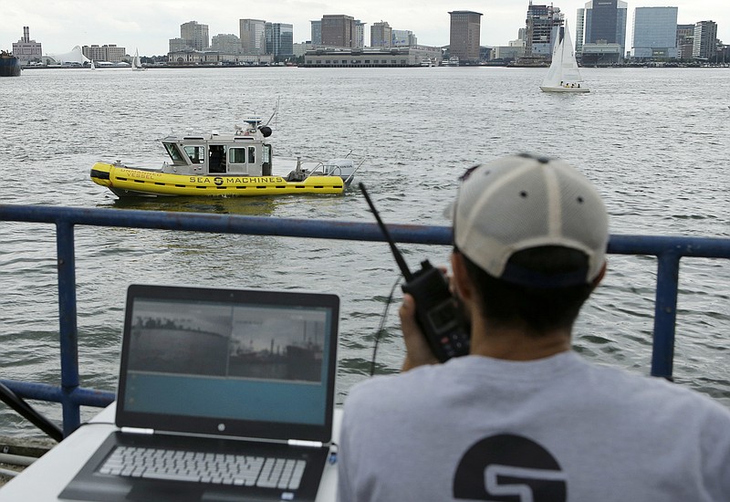 
              In this Aug. 15, 2017 photo, computer scientist Mohamed Saad Ibn Seddik, of Sea Machines Robotics, uses a laptop to guide a boat outfitted with sensors and self-navigating software and capable of autonomous navigation in Boston Harbor. The boat still needs human oversight, but some of the world's biggest maritime firms have committed to designing ships that won't need any captains or crews - at least not on board. (AP Photo/Steven Senne)
            