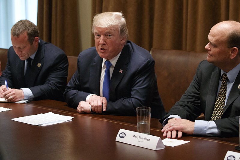 
              Rep. Josh Gottheimer, D-N.J., left, and Rep. Tom Reed, R-N.Y., right, listen as President Donald Trump speaks during a meeting with a bipartisan group of lawmakers in the Cabinet Room of the White House, Wednesday, Sept. 13, 2017, in Washington. (AP Photo/Evan Vucci)
            