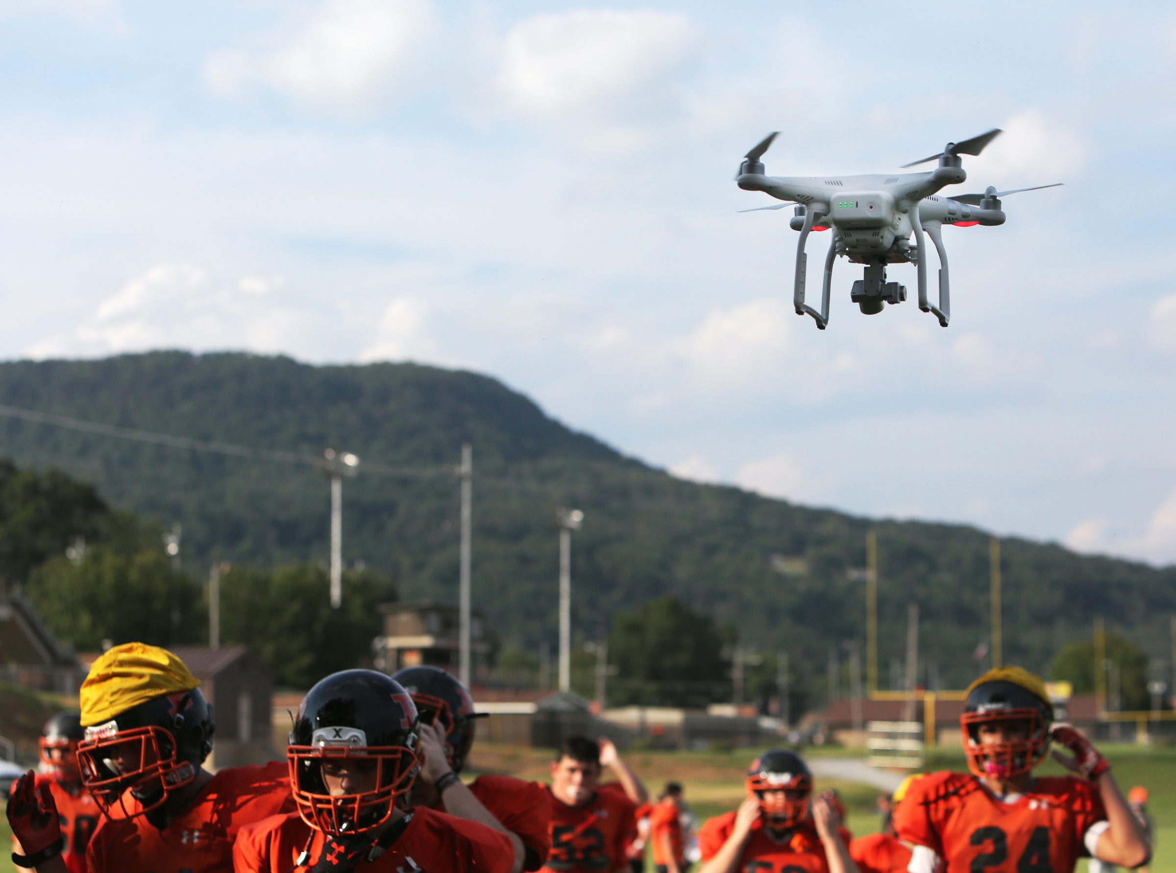 Devin Parker lands a drone as football players take a break, so he can change the batteries Tuesday, Aug. 29, 2017, at South Pittsburg High School in South Pittsburg, Tenn. Coaches give Parker several drills to focus on getting footage of during practices.