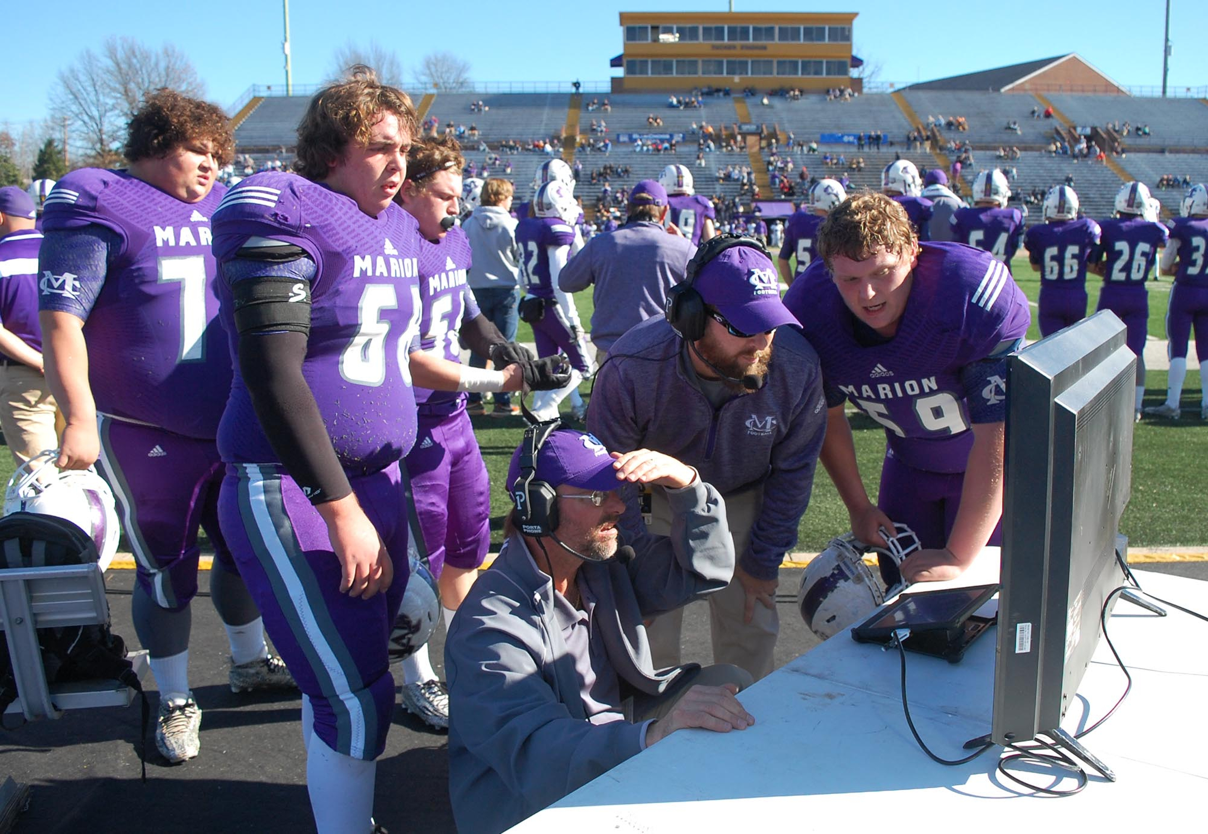 The Warrior coaches go over a video with the offensive line on the sidelines. The Marion County Warriors faced the Trezevant Bears in the Division I Class 2A Tennessee State Football Championships in the BlueCross Bowl at Tennessee Tech's Tucker Stadium on Saturday, December 5, 2015.