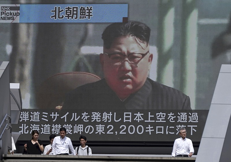 
              People walk past a public TV screen showing a file footage of North Korean leader Kim Jong Un during news on North's missile launch, in Tokyo, Friday, Sept. 15, 2017. North Korea fired an intermediate-range missile over Japan into the northern Pacific Ocean on Friday, U.S. and South Korean militaries said, its longest-ever such flight and a clear message of defiance to its rivals. (AP Photo/Eugene Hoshiko)
            