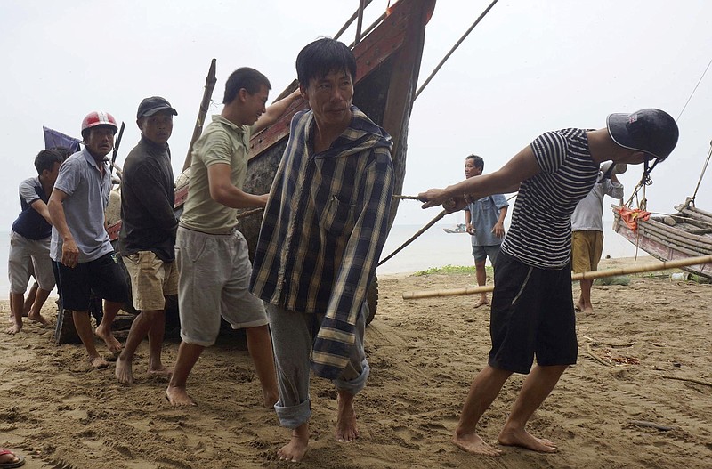 
              Vietnamese villagers move a fishing boat on shore in northern Thanh Hoa province, Vietnam, Thursday, Sept. 14, 2017. Vietnam on Thursday was bracing for typhoon Doksuri, which is expected to be the most powerful tropical cyclone to hit the Southeast Asian country in several years. (Trinh Duy Hung/Vietnam News Agency via AP)
            