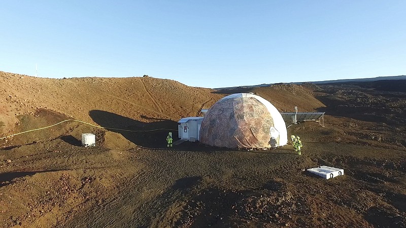 
              This 2017 photo released by the University of Hawaii shows crew members walking around the university’s Hawaii Space Exploration Analog and Simulation (HI-SEAS) on Mauna Loa volcano, Big Island, Hawaii. After eight months of living in isolation on a remote Hawaii volcano, six NASA-backed space psychology research subjects will emerge from their Mars-like habitat on Sunday, Sept. 17, 2017. The participants are in a study designed to better understand the psychological impacts of a long-term manned mission to space on astronauts. NASA hopes to send humans to Mars by the 2030s. (University of Hawaii via AP)
            