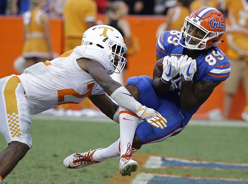 Florida wide receiver Tyrie Cleveland, right, catches the game winning 63-yard touchdown pass in front of Tennessee defensive back Micah Abernathy (22) as time expired in the fourth quarter of an NCAA college football game, Saturday, Sept. 16, 2017, in Gainesville, Fla. Florida won 26-20. (AP Photo/John Raoux)
