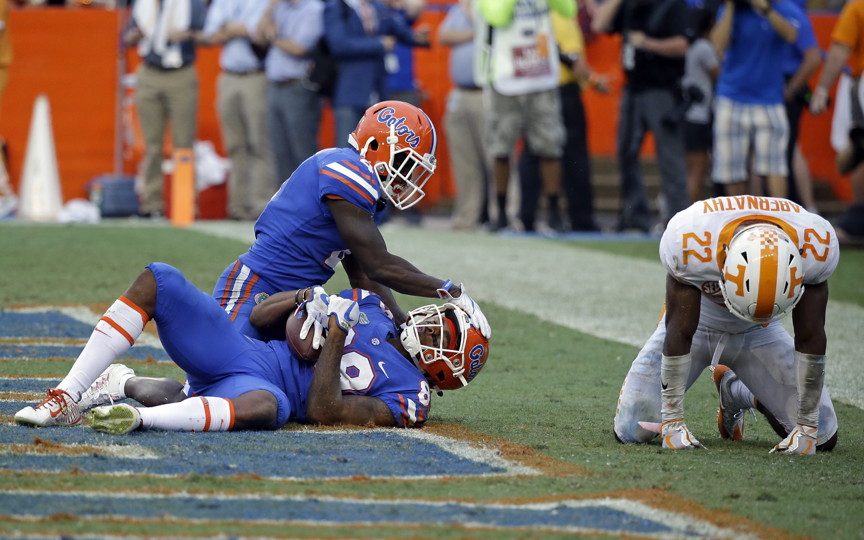 Florida's Tyrie Cleveland, bottom left, celebrates his game-winning touchdown with fellow wide receiver Brandon Powell as Tennessee defensive back Micah Abernathy hangs his head in despair after the Vols lost 26-20.