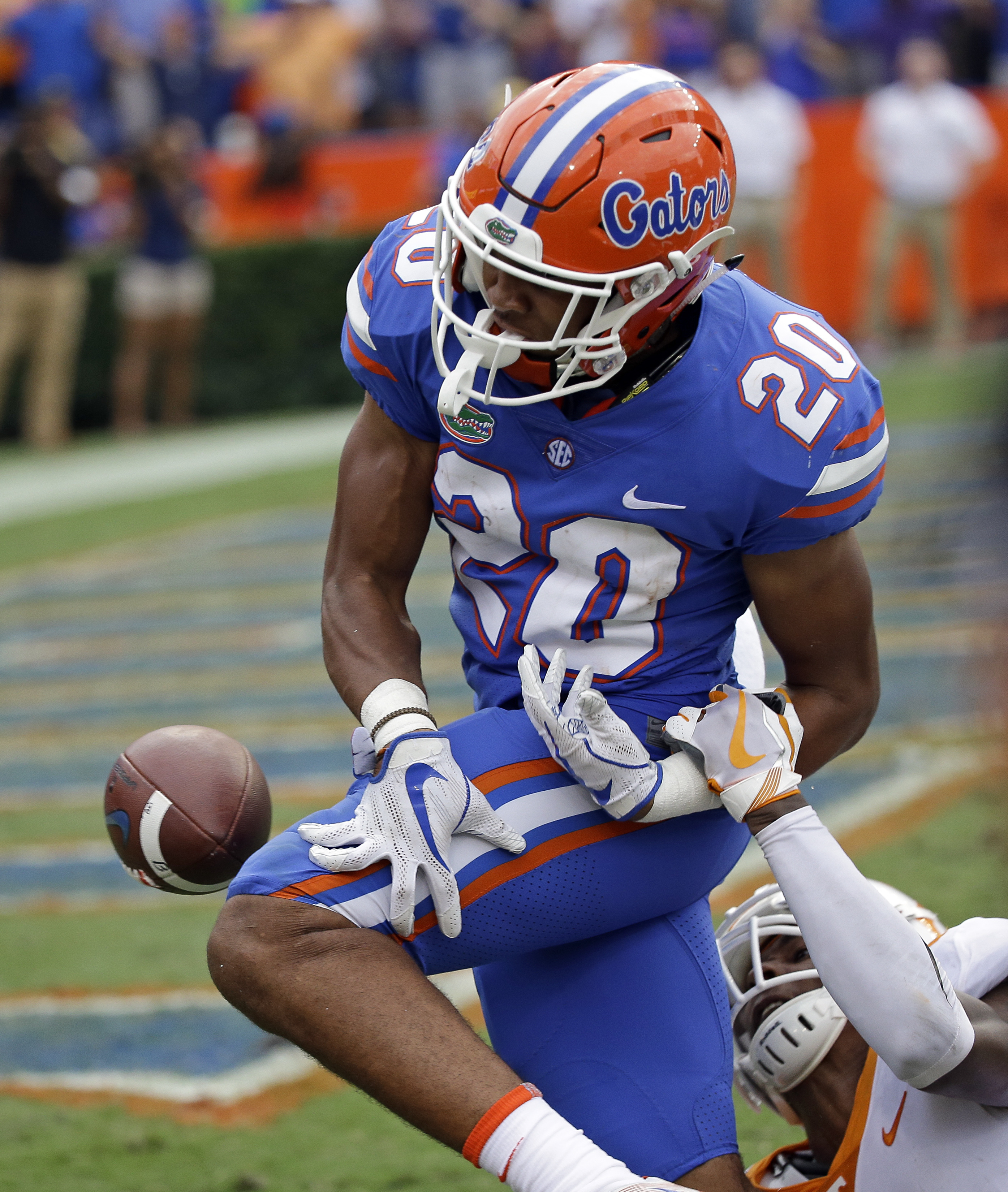 Tennessee defensive back Justin Martin, bottom right, knocks the ball loose from Florida running back Malik Davis (20) on the 2-yard line after Davis had run 72-yards during the second half of an NCAA college football game, Saturday, Sept. 16, 2017, in Gainesville, Fla. The ball rolled out of the end zone for a touchback. Florida won 26-20. (AP Photo/John Raoux)