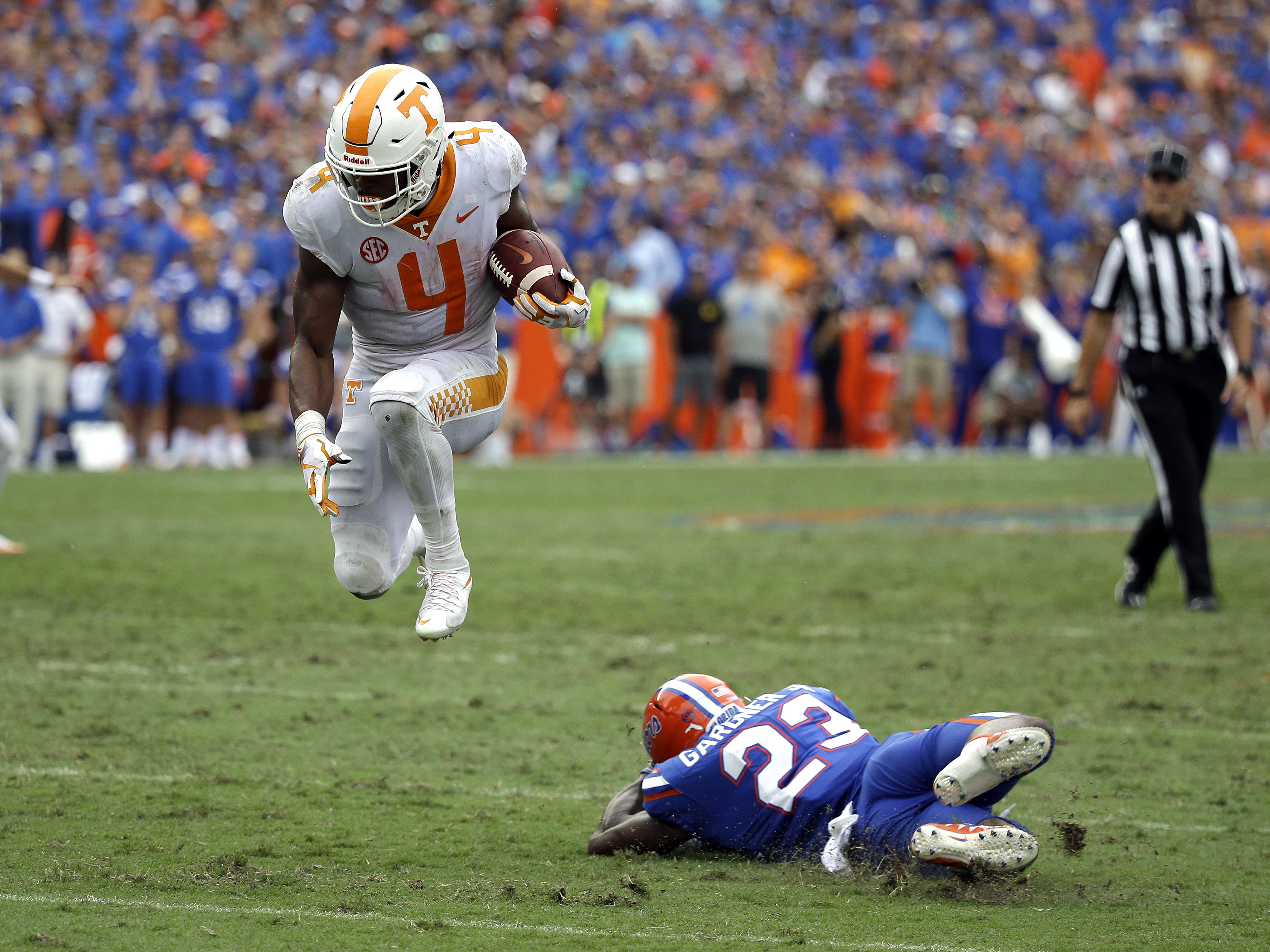 Tennessee running back John Kelly (4) leaps over Florida defensive back Chauncey Gardner Jr. (23) for extra yardage on a run in the second half of an NCAA college football game, Saturday, Sept. 16, 2017, in Gainesville, Fla. Florida won 26-20. (AP Photo/John Raoux)