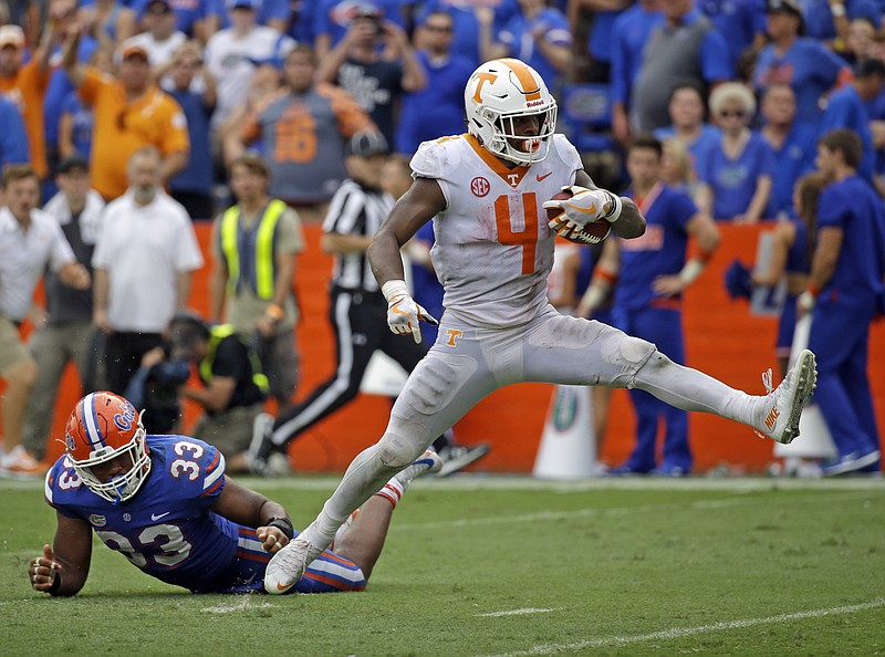 Tennessee running back John Kelly heads past Florida linebacker David Reese on his way to the end zone during a 34-yard touchdown run in the fourth quarter of Saturday's game in Gainesville.