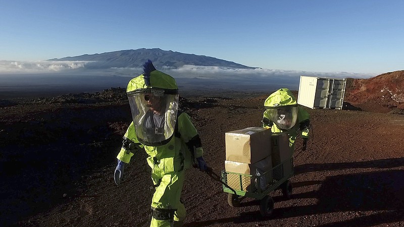 
              In this 2017 photo released by the University of Hawaii crew members of Mission V, walk up hill with a cart next to the university’s facility Hawaii Space Exploration Analog and Simulation (HI-SEAS) at the Mauna Loa volcano, Big Island, Hawaii. After eight months of living in isolation on a remote Hawaii volcano, six NASA-backed space psychology research subjects will emerge from their Mars-like habitat on Sunday, Sept. 17, 2017. The participants are in a study designed to better understand the psychological impacts of a long-term manned mission to space on astronauts. NASA hopes to send humans to Mars by the 2030s. (University of Hawaii via AP)
            