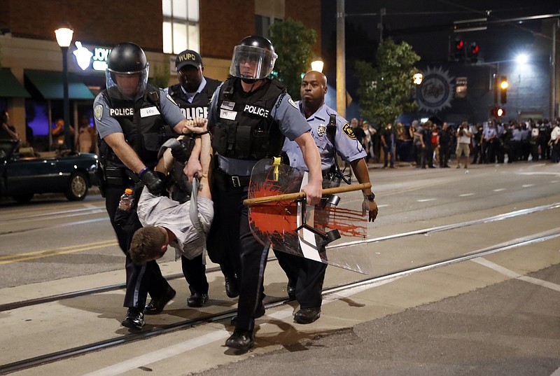 Police arrest a man as they try to clear a violent crowd Saturday, Sept. 16, 2017, in University City, Mo. Earlier, protesters marched peacefully in response to a not guilty verdict in the trial of former St. Louis police officer Jason Stockley. (AP Photo/Jeff Roberson)