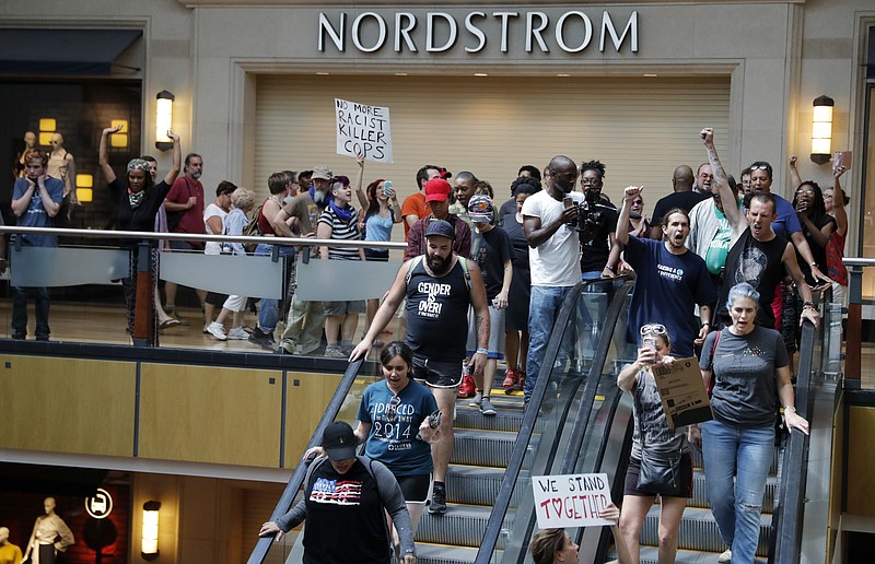 Protesters march through West County Mall in response to a not guilty verdict in the trial of a former St. Louis police officer on Saturday in Des Peres, Mo.