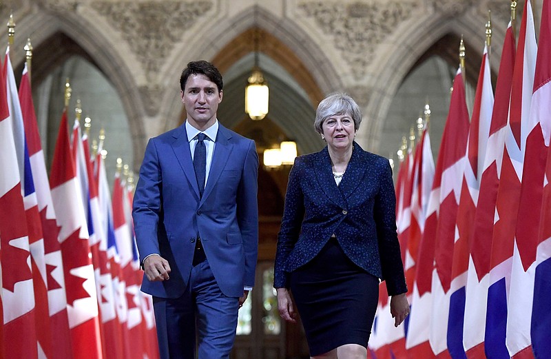 
              Prime Minister Justin Trudeau and British Prime Minister Theresa May walk in the Hall of Honour on Parliament Hill in Ottawa, Ontario, during a visit on Monday, Sept. 18, 2017. (Justin Tang/The Canadian Press via AP)
            