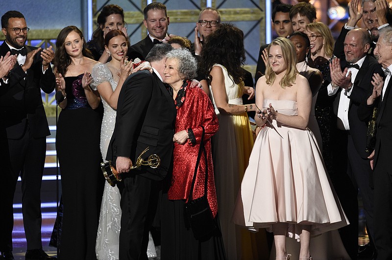 
              Bruce Miller, from left, Margaret Atwood, and Elisabeth Moss accept the award for outstanding drama series for "The Handmaid's Tale" at the 69th Primetime Emmy Awards on Sunday, Sept. 17, 2017, at the Microsoft Theater in Los Angeles. (Photo by Chris Pizzello/Invision/AP)
            