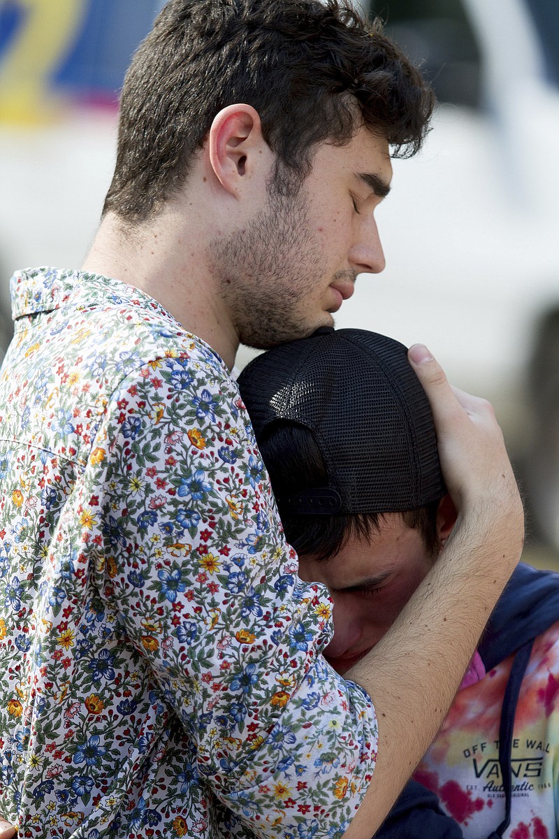 
              In this photo taken Sept. 17, 2017, mourners hug at a memorial for Georgia Tech student Scout Schultz in Atlanta, Ga. Schultz was a 21-year-old who was shot and killed during a confrontation with police on campus Saturday, Sept. 16. (Steve Schaefer/Atlanta Journal-Constitution via AP)
            