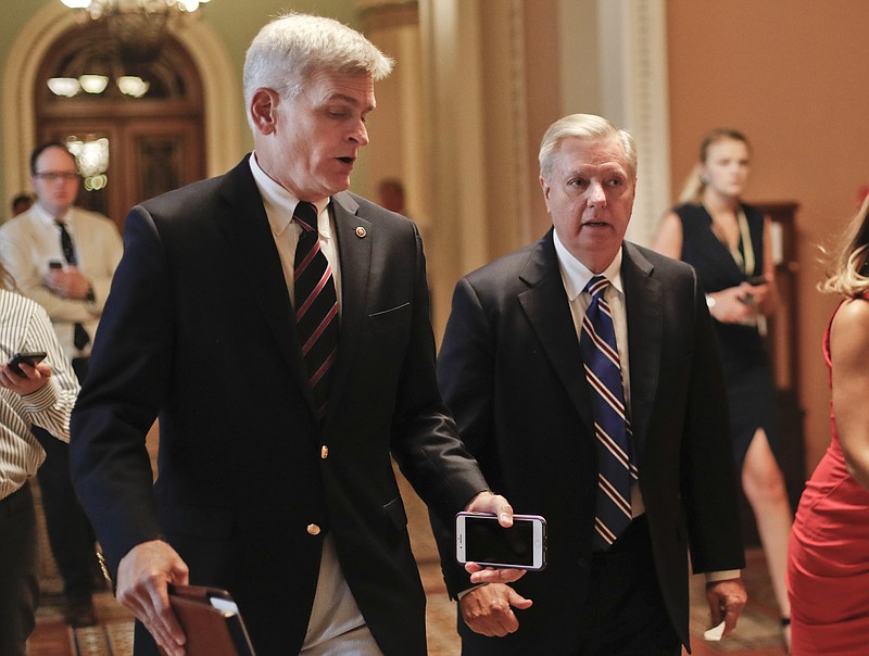 
              FILE - In this July 13, 2017, file photo, Sen. Bill Cassidy, R-La., left, and Sen. Lindsey Graham, R-S.C., right, talk while walking to a meeting on Capitol Hill in Washington. Senate Republicans are planning a final, uphill push to erase President Barack Obama's health care law. But Democrats and their allies are going all-out to stop the drive. The initial Republican effort crashed in July in the GOP-run Senate. Majority Leader Mitch McConnell said after that defeat that he'd not revisit the issue without the votes to succeed. Graham and Cassidy are leading the new GOP charge and they'd transform much of Obama's law into block grants and let states decide how to spend the money. (AP Photo/Pablo Martinez Monsivais, File)
            