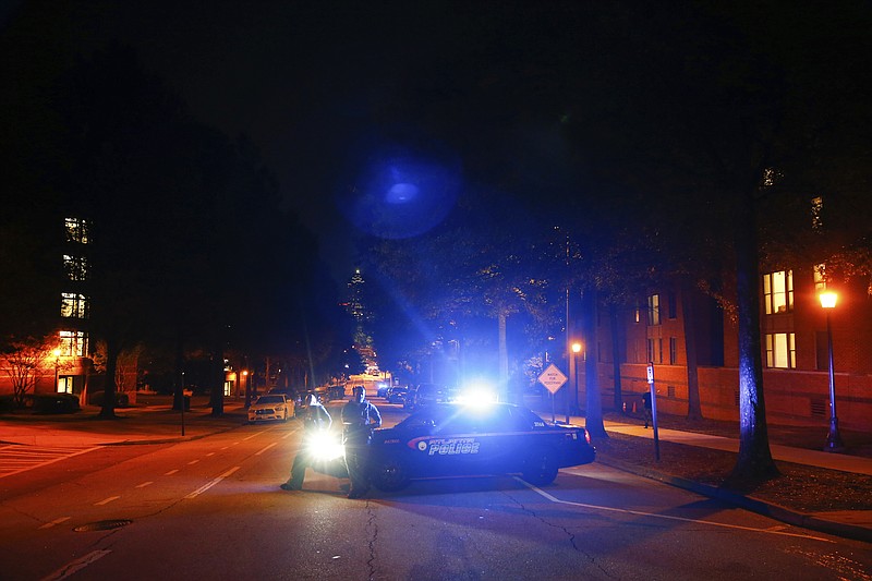 Police block off streets in front of a police station at Georgia Tech where protests happened earlier and at least one police car was burned on Monday, Sept. 18, 2017, in Atlanta. Protesters were demonstrating against the shooting, which resulted in a fatality, of a student on Saturday. (AP Photo/Kevin D. Liles)