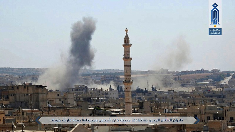 
              This undated photo released Tuesday, Sept 19, 2017 by the al-Qaida-affiliated Ibaa News Agency, that is consistent with independent AP reporting, shows smoke rising over buildings that were hit by Syrian government forces bombardment, in Khan Sheikhoun, in the northern province of Idlib, Syria. A Syrian monitoring group says insurgents led by an al-Qaida-linked group have launched a wide offensive against pro-government troops south of their stronghold in the western province of Idlib. Arabic reads, "Criminal regime air force targets Khan Sheikhoun city with a number of raids" (Ibaa News Agency, via AP)
            