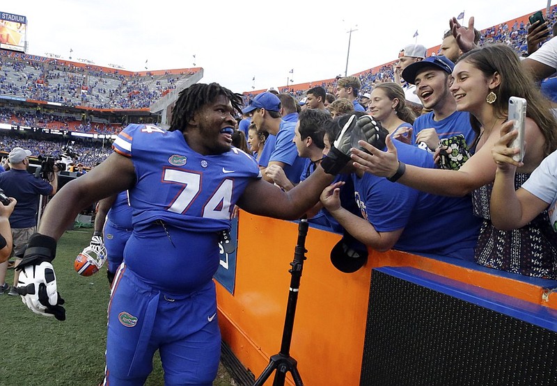 Florida offensive lineman Fred Johnson (74) celebrates with fans after the Gators' 26-20 win against Tennessee last Saturday in Gainesville. It was the program's fifth straight victory in a one-possession game, and the Gators are 8-1 in such games under third-year coach Jim McElwain.