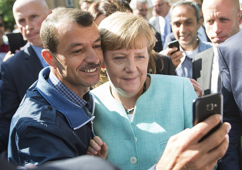 
              FILE - This Sept. 10, 2015 file photo shows German Chancellor Angela Merkel taking a selfie with a refugee at the refugee reception center in Berlin, Germany. Two years after her controversial decision to open Germany’s doors to hundreds of thousands of migrants, Merkel is on track to winning her 4th term in national elections this month. (Bernd von Jutrczenka/dpa via AP, file)
            