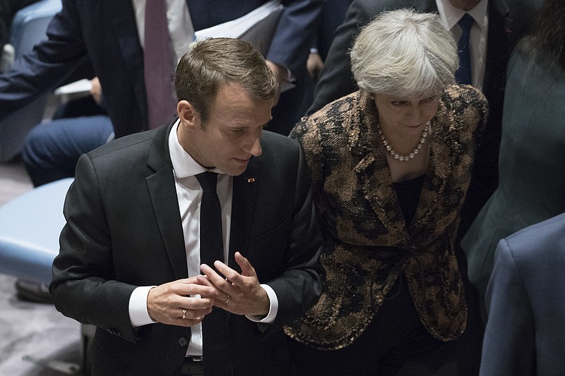 
              French President Emmanuel Macron speaks to British Prime Minister Theresa May as they leave a high level Security Council meeting on United Nations peacekeeping operations, Wednesday, Sept. 20, 2017 at U.N. headquarters. (AP Photo/Mary Altaffer)
            
